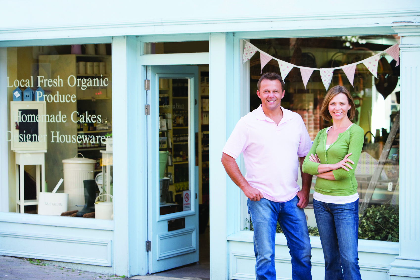 Couple standing in front of organic food store smiling